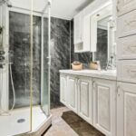 Badsanierung Klagenfurt 4 – klassisches Bad mit Marmorfliesen und Glasdusche, Wank-Center